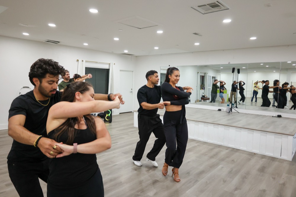 Dancers rehearsing footwork drills in the studio.