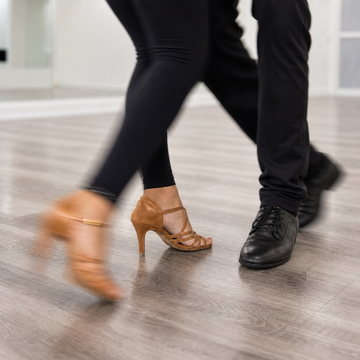 Close-up of Salsa footwork on a light gray studio floor.