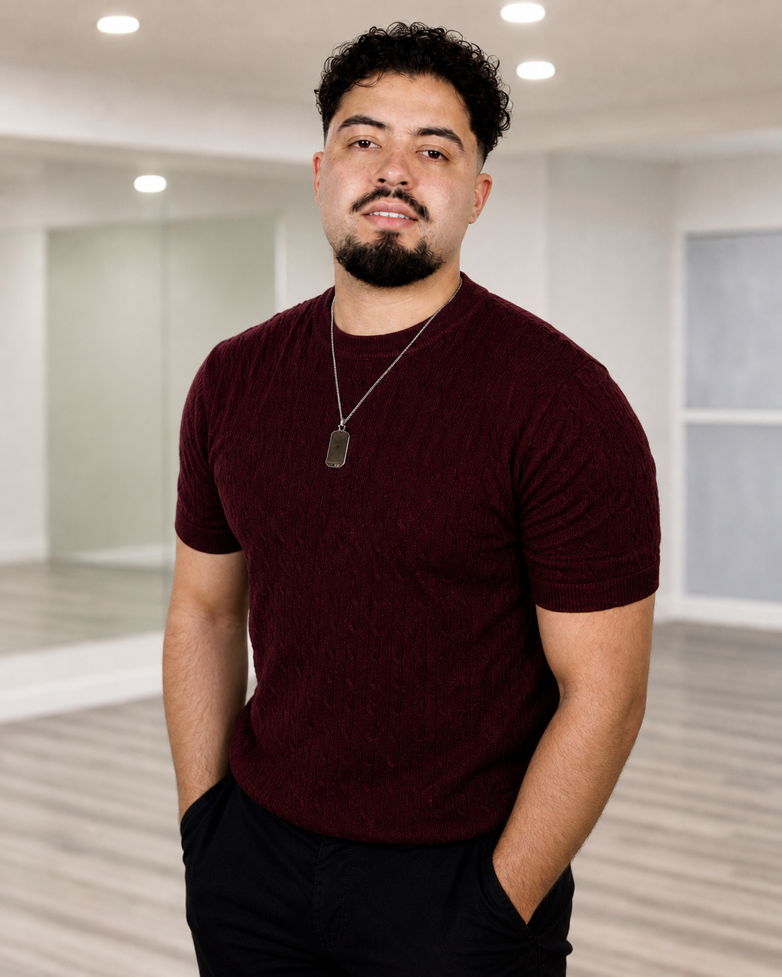 Portrait of Junior Herrera in a bright white dance studio.